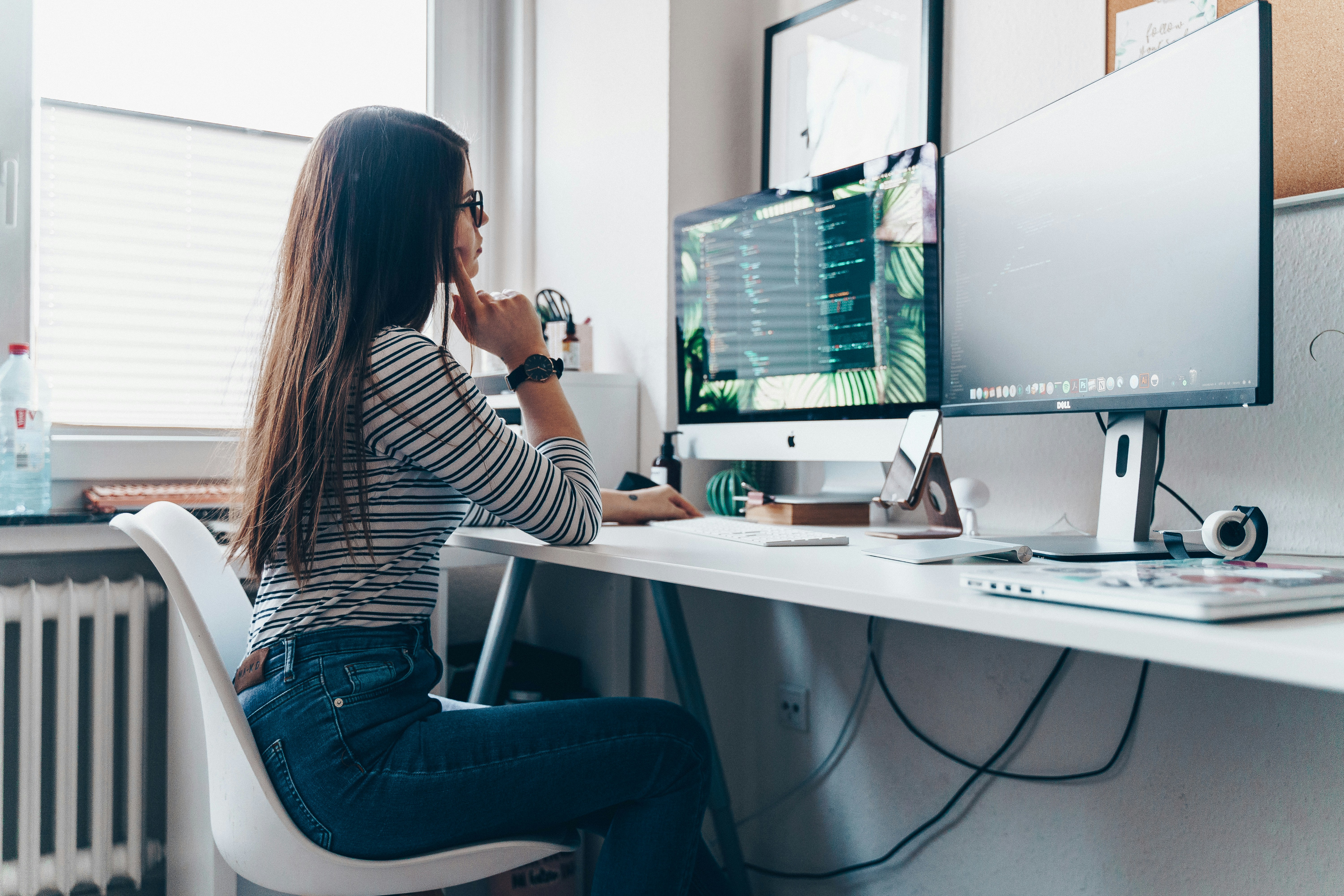 A woman sitting at a desk working at a desktop computer